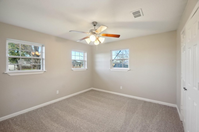 unfurnished room with ceiling fan and carpet