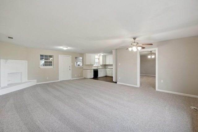 unfurnished living room with ceiling fan and light carpet