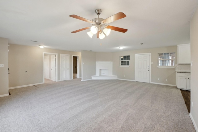 unfurnished living room with ceiling fan and light carpet