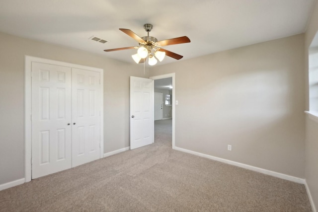 unfurnished bedroom with a closet, ceiling fan, and carpet floors