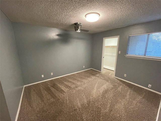 empty room featuring a textured ceiling, ceiling fan, and carpet floors