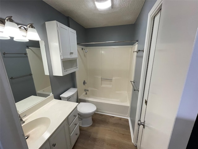 full bathroom featuring toilet, hardwood / wood-style floors, a textured ceiling, tub / shower combination, and vanity