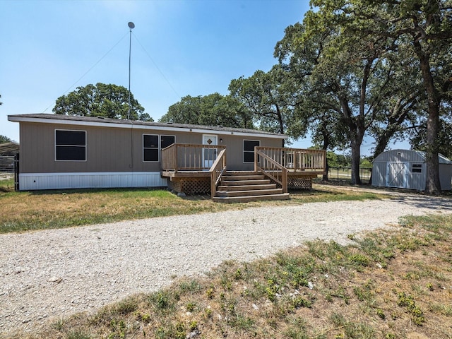 view of front facade with a storage unit and a wooden deck