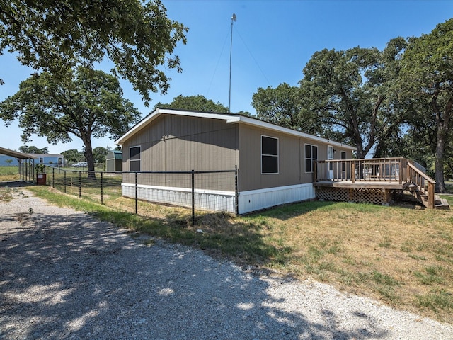 view of side of property with a lawn and a deck