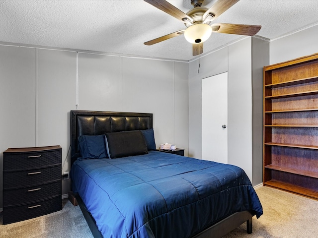 carpeted bedroom with ceiling fan and a textured ceiling