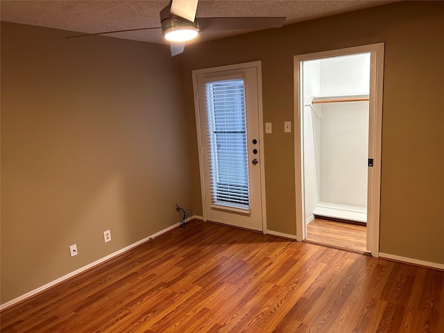 spare room with a textured ceiling, ceiling fan, and hardwood / wood-style floors