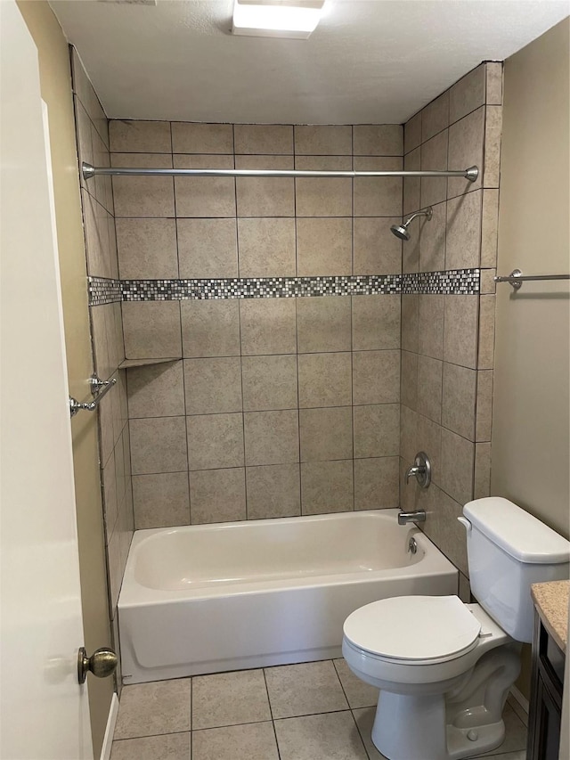 full bathroom featuring tiled shower / bath, tile patterned floors, vanity, and toilet