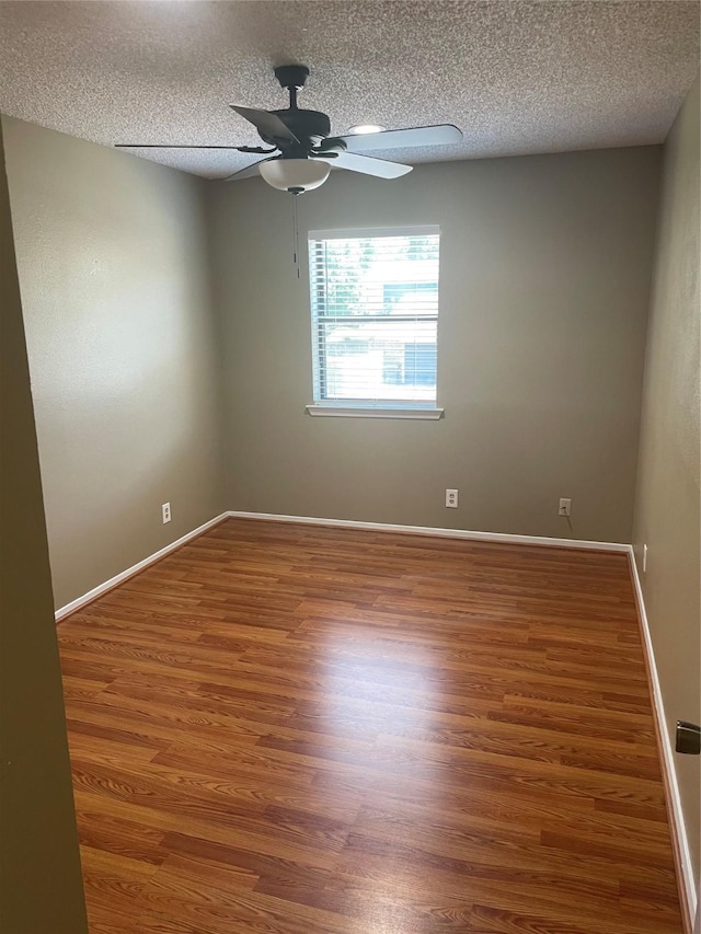 unfurnished room with ceiling fan, wood-type flooring, and a textured ceiling