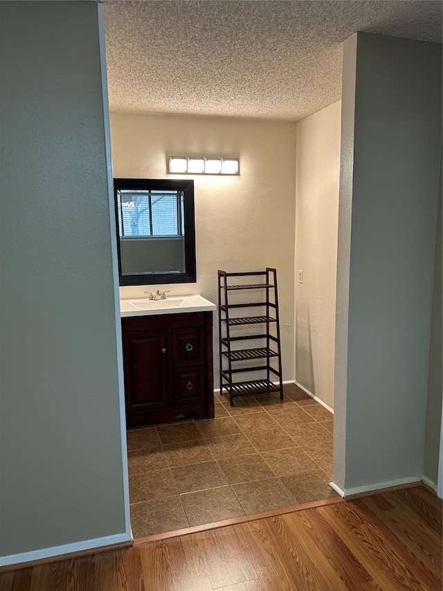 bathroom featuring hardwood / wood-style flooring, a textured ceiling, and vanity