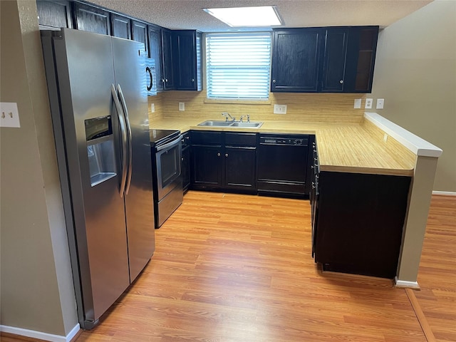 kitchen with a textured ceiling, appliances with stainless steel finishes, light hardwood / wood-style flooring, and sink