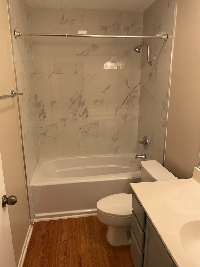 full bathroom with toilet, tiled shower / bath, wood-type flooring, and vanity