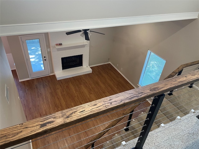 unfurnished living room with ceiling fan and a fireplace