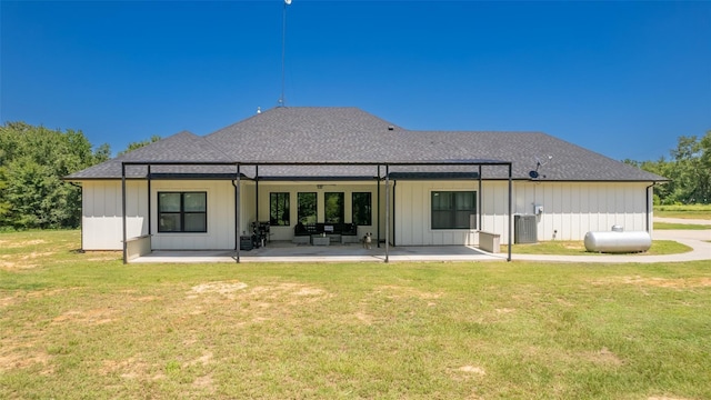 back of property featuring central AC unit, a lawn, and a patio