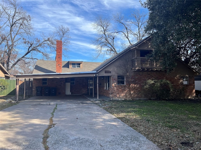 view of front of home with a balcony and a carport