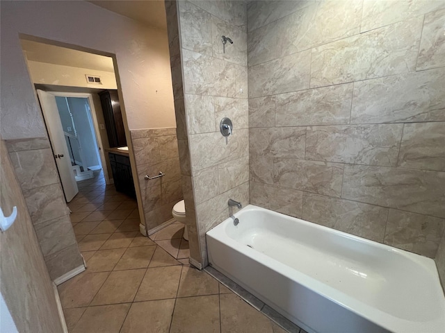 bathroom featuring tile walls, tile patterned floors, and toilet