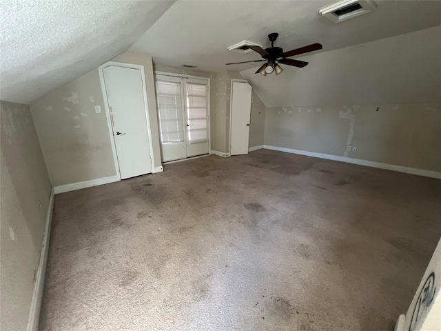 bonus room featuring ceiling fan, a textured ceiling, vaulted ceiling, and carpet flooring