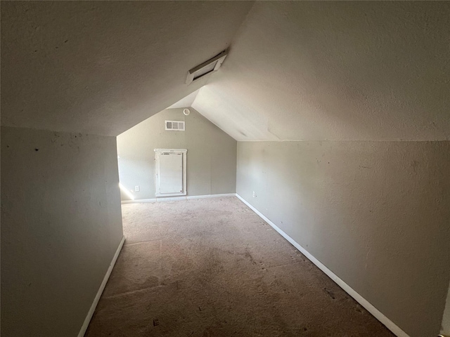 additional living space featuring vaulted ceiling and carpet