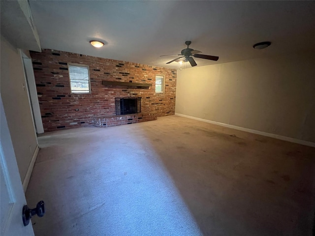 unfurnished living room featuring a brick fireplace, brick wall, and ceiling fan