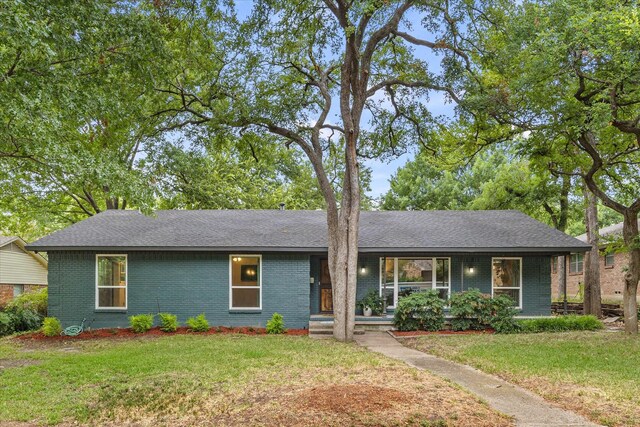 ranch-style home with covered porch and a front yard