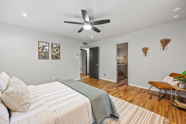 bedroom featuring ceiling fan, connected bathroom, and hardwood / wood-style flooring