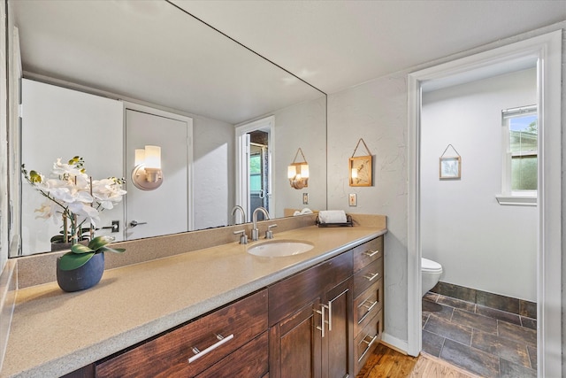 bathroom featuring hardwood / wood-style flooring, toilet, and vanity