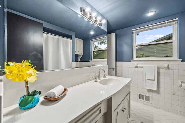 bathroom featuring vanity, tile patterned floors, and tile walls