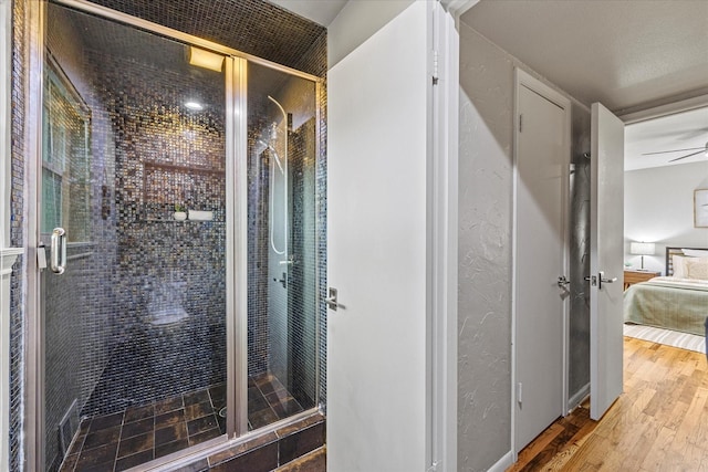 bathroom with hardwood / wood-style flooring and walk in shower