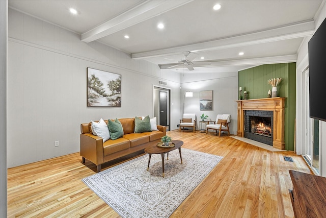 living room featuring ceiling fan, beam ceiling, and light hardwood / wood-style flooring