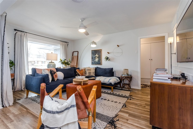 living room with ceiling fan and light wood-type flooring