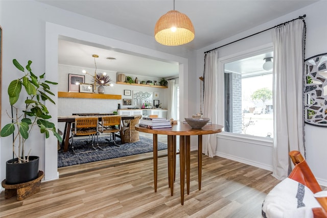 dining area with an inviting chandelier and light hardwood / wood-style flooring