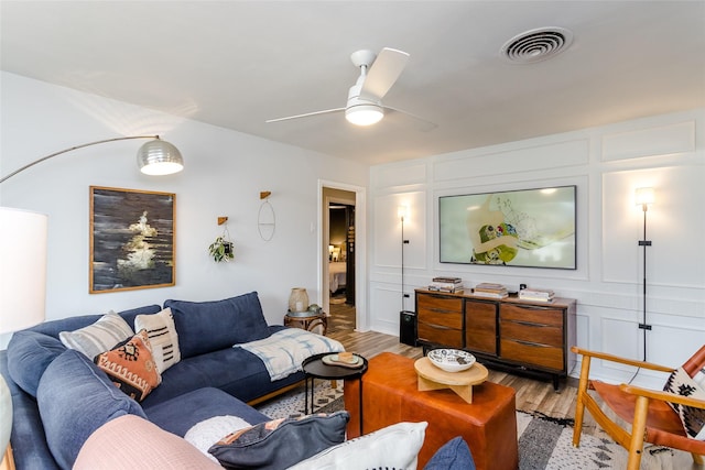 living room featuring ceiling fan and light hardwood / wood-style floors