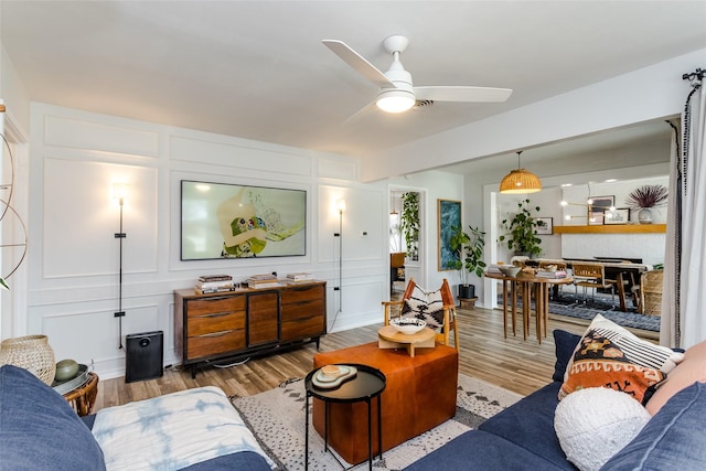 living room with hardwood / wood-style flooring and ceiling fan