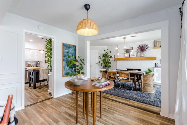 dining space with a notable chandelier and light hardwood / wood-style floors