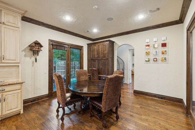 dining room with dark wood-type flooring and crown molding