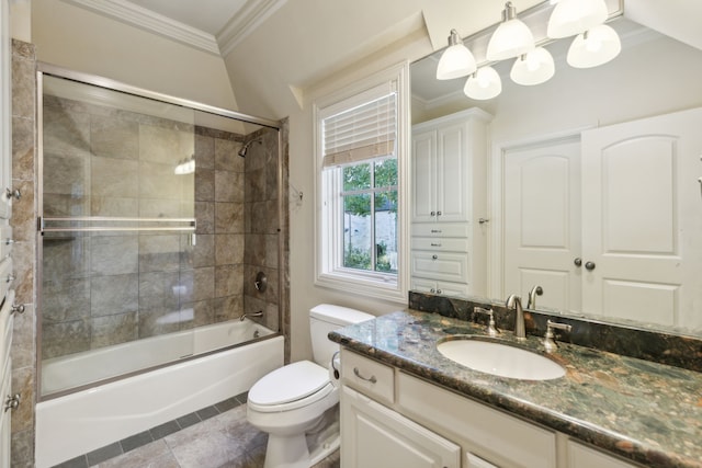 full bathroom featuring toilet, tile patterned floors, ornamental molding, vanity, and shower / bath combination with glass door