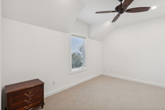 empty room featuring ceiling fan, light colored carpet, and lofted ceiling