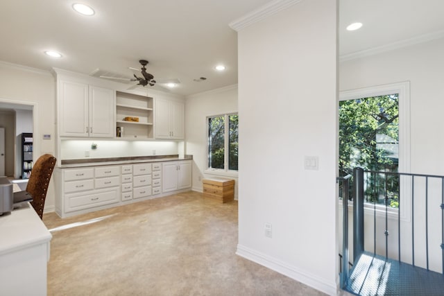 kitchen featuring ceiling fan, white cabinetry, crown molding, and a wealth of natural light