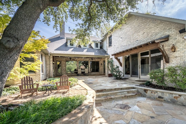 rear view of house with ceiling fan and a patio area