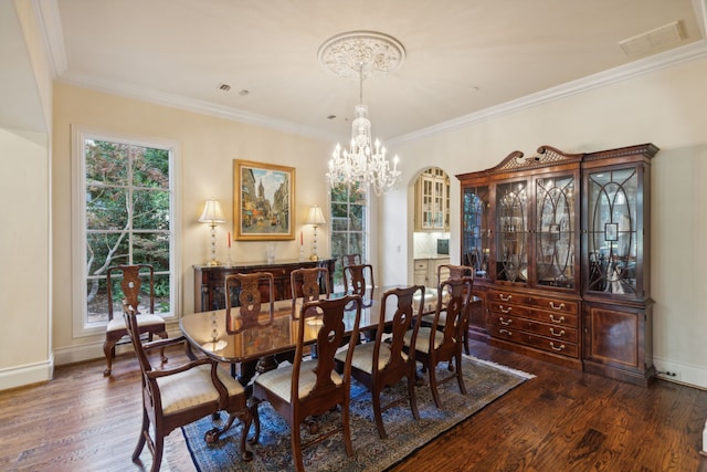 dining area with an inviting chandelier, dark wood-type flooring, and crown molding