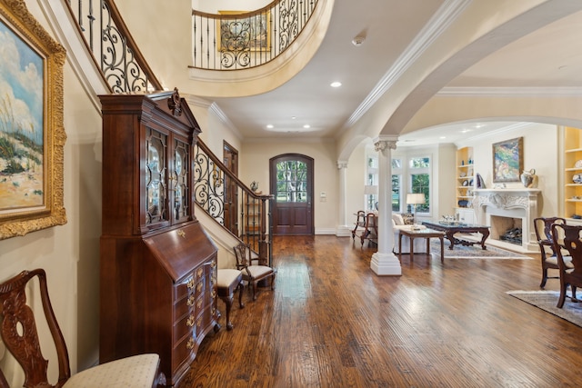 entrance foyer with crown molding, dark hardwood / wood-style floors, and ornate columns