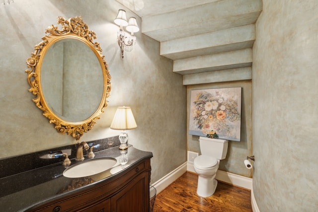 bathroom with toilet, hardwood / wood-style floors, and vanity