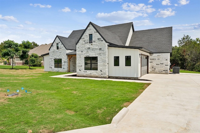 view of front of home with central AC unit, a garage, and a front yard