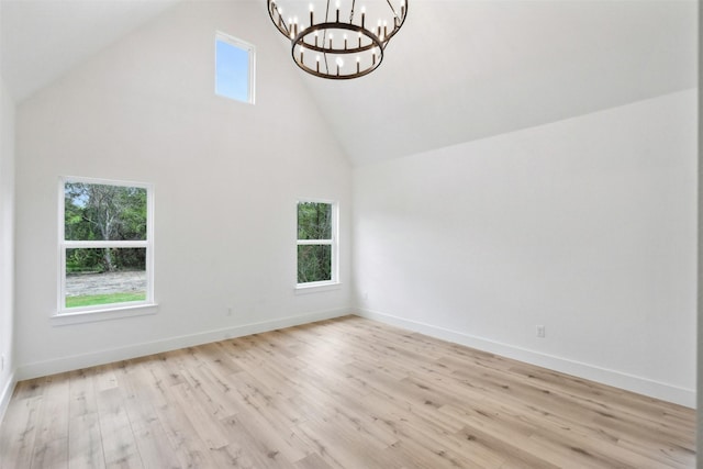 interior space featuring high vaulted ceiling, a wealth of natural light, light hardwood / wood-style flooring, and a notable chandelier