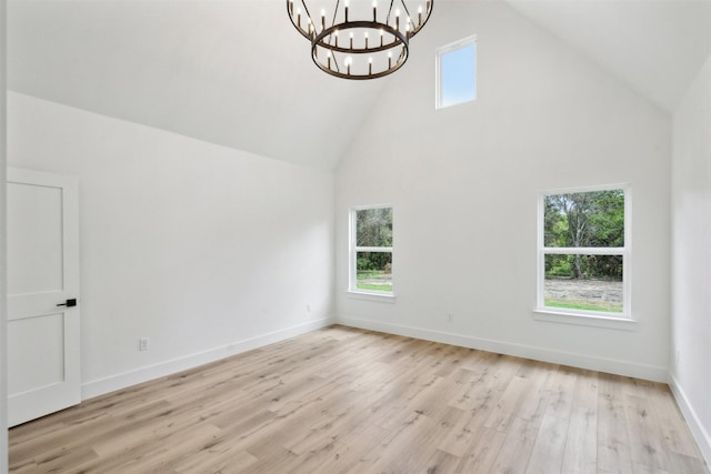 interior space with a chandelier, a healthy amount of sunlight, light hardwood / wood-style flooring, and high vaulted ceiling