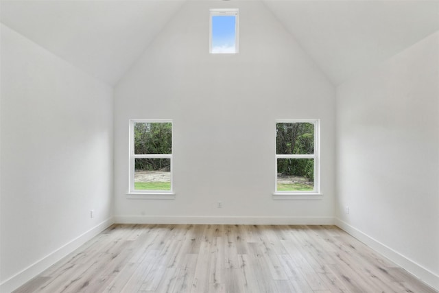 spare room with light hardwood / wood-style flooring and high vaulted ceiling