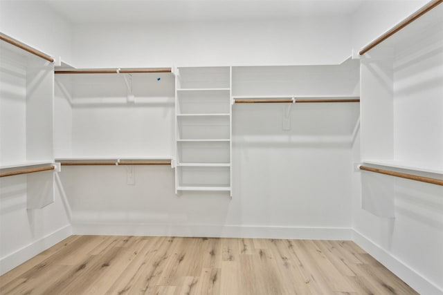 walk in closet with light hardwood / wood-style flooring