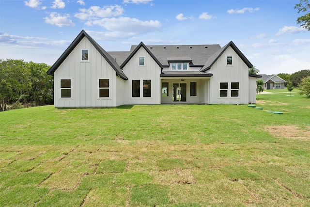 rear view of property with ceiling fan and a lawn