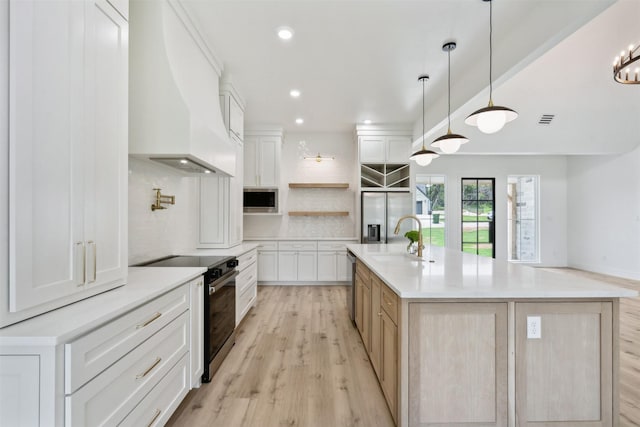 kitchen with stainless steel appliances, custom exhaust hood, white cabinetry, and a large island