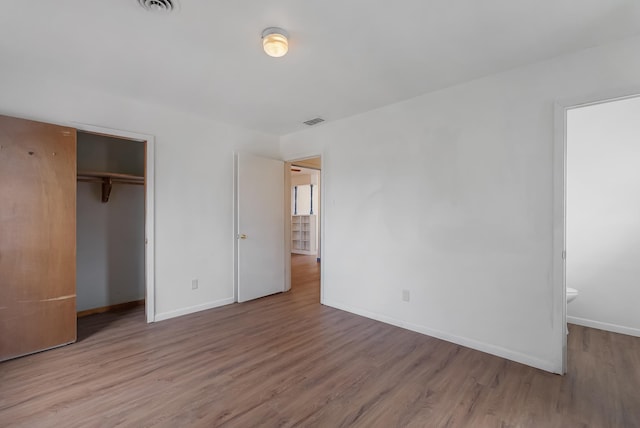 unfurnished bedroom with a closet and hardwood / wood-style flooring