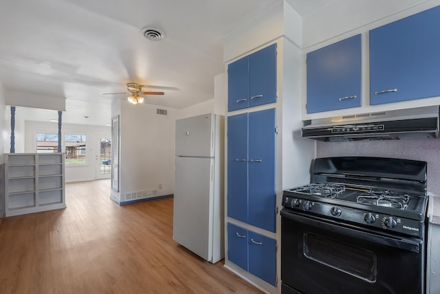 kitchen with hardwood / wood-style flooring, ceiling fan, black gas range oven, blue cabinets, and white refrigerator